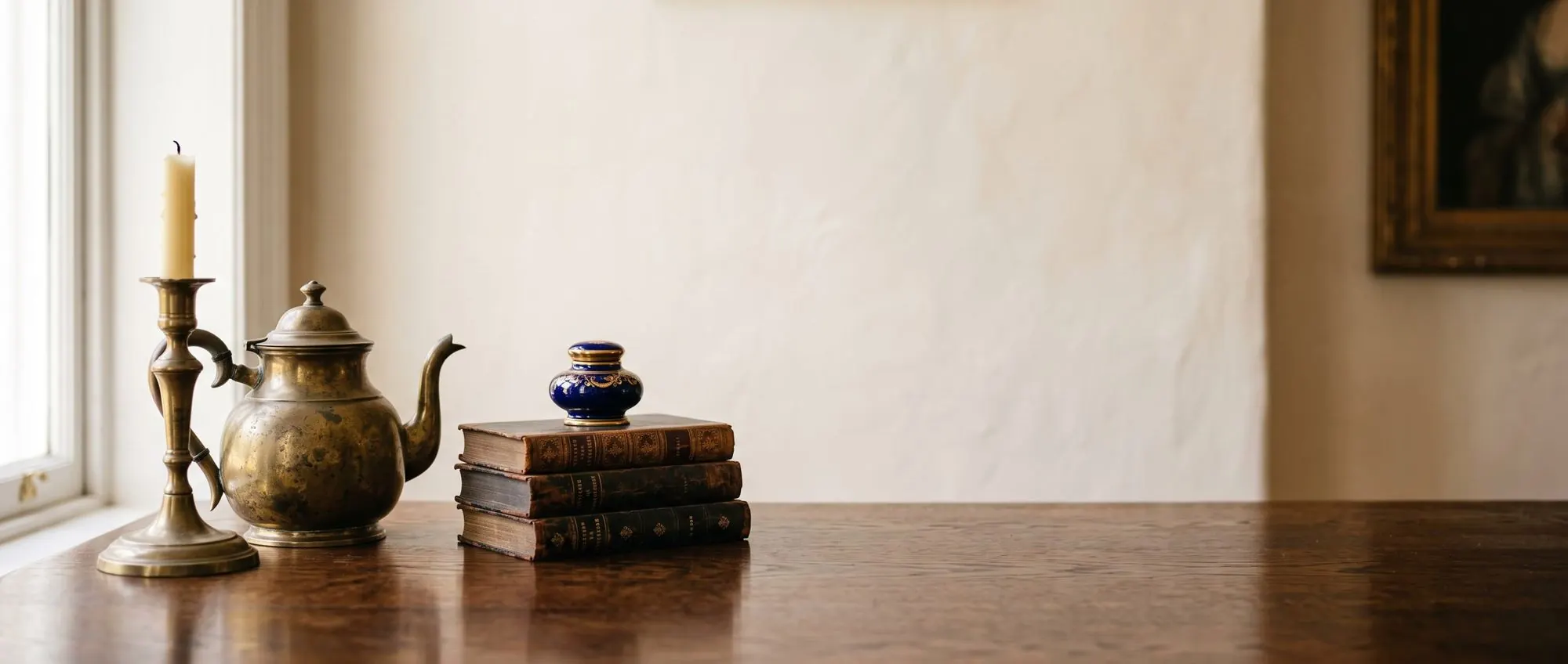 Brass candlestick and antiques on a wooden table, warm light